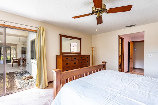 tiled bedroom with a textured ceiling and ceiling fan