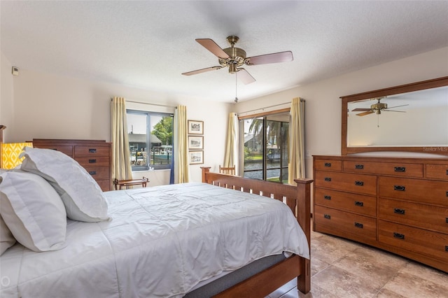 bedroom with a ceiling fan and a textured ceiling