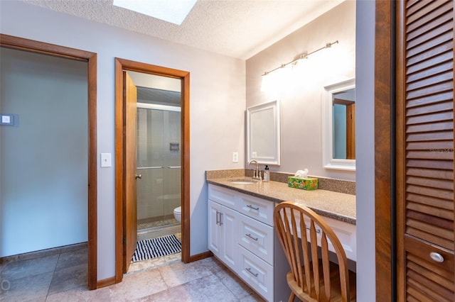 bathroom with toilet, a textured ceiling, tile patterned floors, and vanity