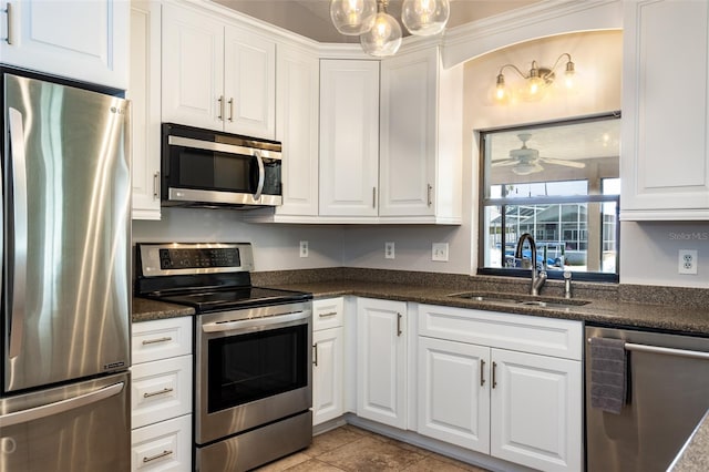 kitchen with ceiling fan, a sink, white cabinetry, appliances with stainless steel finishes, and decorative light fixtures