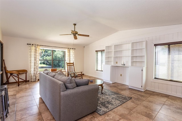 living room with vaulted ceiling, a ceiling fan, and baseboards