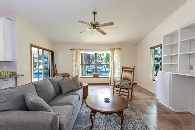 living room featuring lofted ceiling, a healthy amount of sunlight, ceiling fan, and a textured ceiling