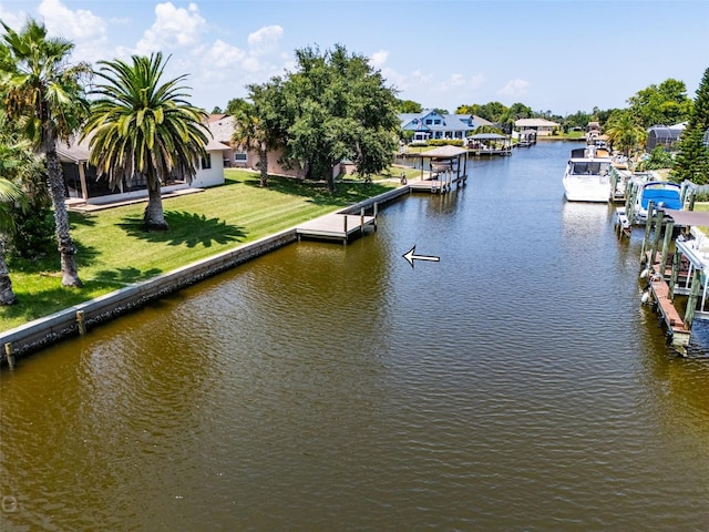 view of dock with a water view, a residential view, and a yard