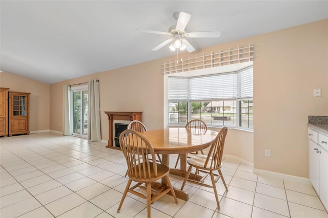 tiled dining room with ceiling fan and vaulted ceiling