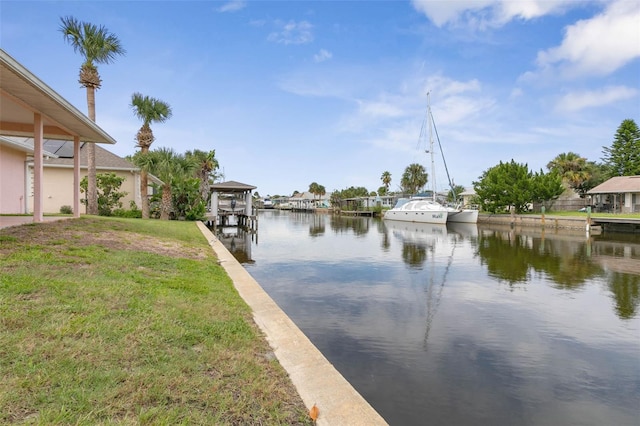 view of dock with a water view and a lawn