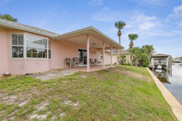 rear view of property featuring a yard and a patio