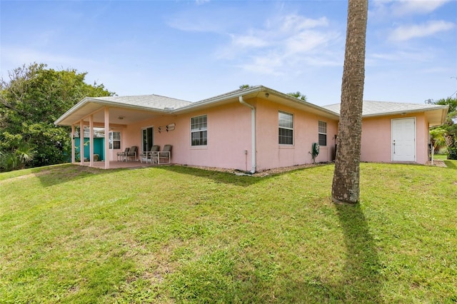 rear view of house featuring a patio and a lawn