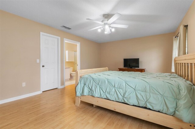 bedroom with connected bathroom, light wood-type flooring, and ceiling fan