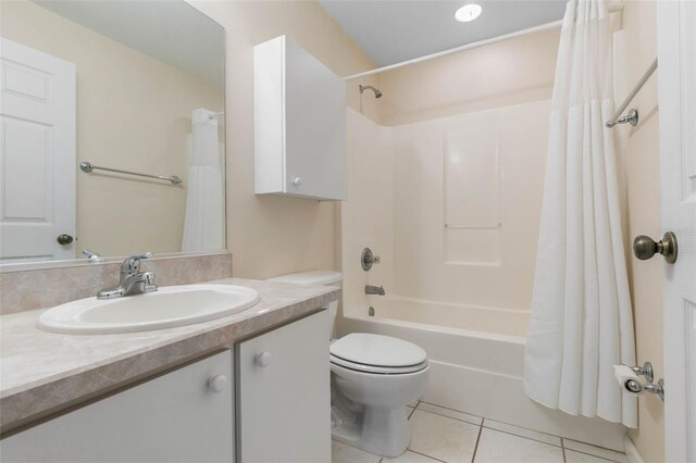 full bathroom featuring tile patterned flooring, shower / bath combo with shower curtain, toilet, and vanity