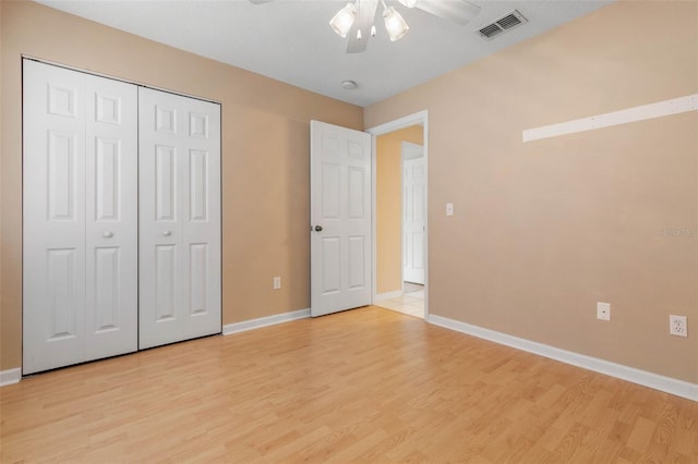 unfurnished bedroom with light hardwood / wood-style flooring, a closet, and ceiling fan