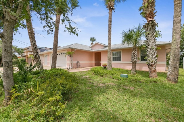 single story home with a garage and a front lawn