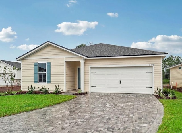 ranch-style home featuring a garage and a front lawn