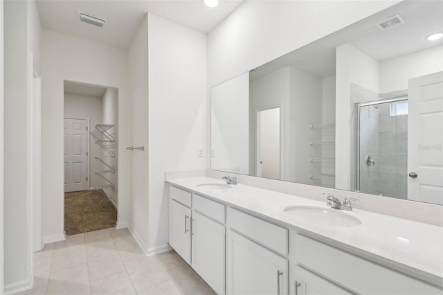 bathroom with tile patterned flooring, vanity, and walk in shower