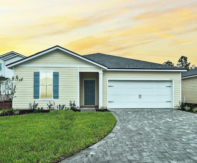 single story home with a lawn and a garage