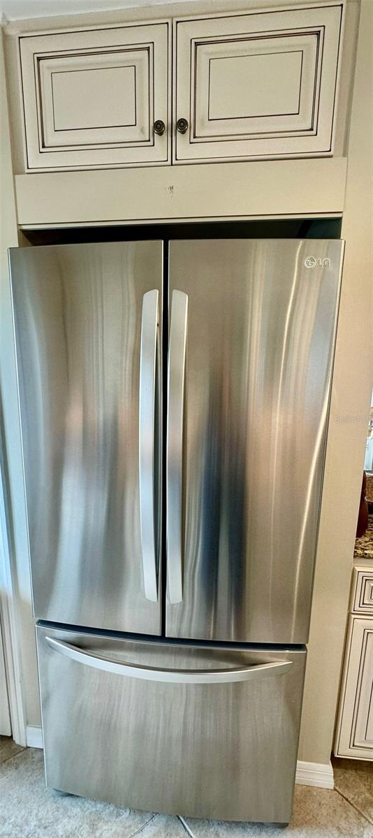 room details with cream cabinetry and stainless steel refrigerator