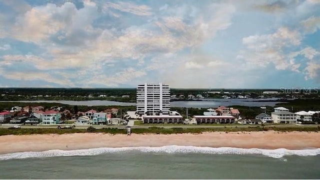 birds eye view of property featuring a beach view and a water view