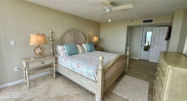 bedroom featuring a textured ceiling, ceiling fan, and tile patterned floors