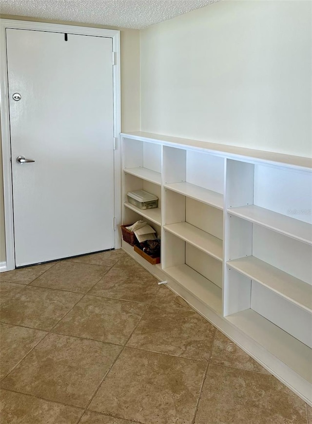 interior space with a textured ceiling and tile patterned floors