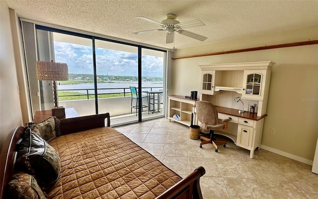 bedroom featuring access to outside, a textured ceiling, light tile patterned floors, and a water view