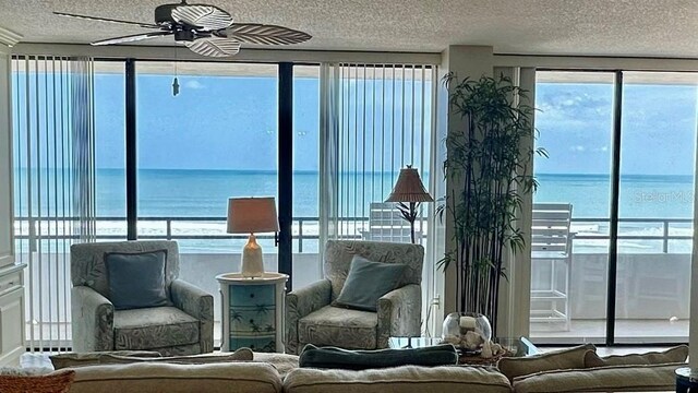 interior space with ceiling fan, a textured ceiling, and a water view