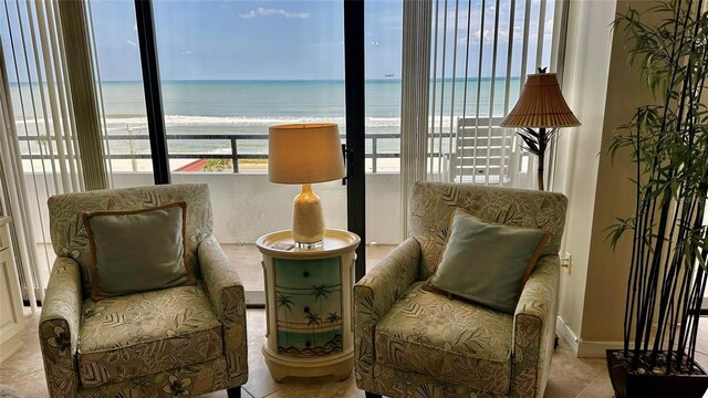 living area featuring a water view and light tile patterned floors