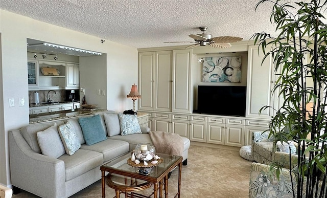 tiled living room featuring ceiling fan, sink, and a textured ceiling