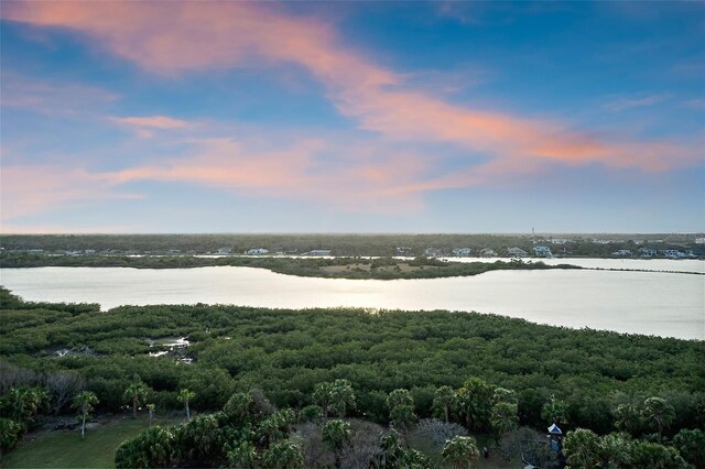 aerial view at dusk featuring a water view