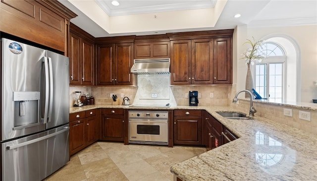 kitchen with appliances with stainless steel finishes, wall chimney exhaust hood, light stone counters, and backsplash