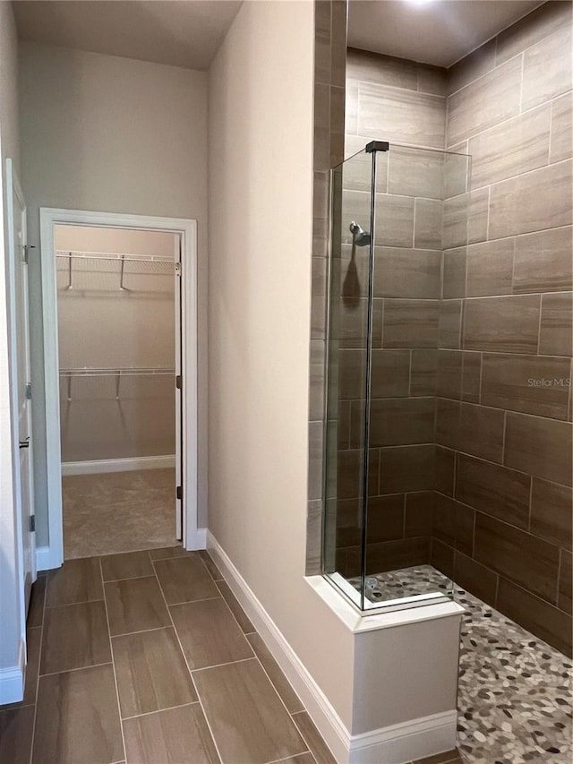201 Hawthorn Ave, Palm Coast, FL 32164 - full bathroom featuring tiled shower, a spacious closet, and baseboards