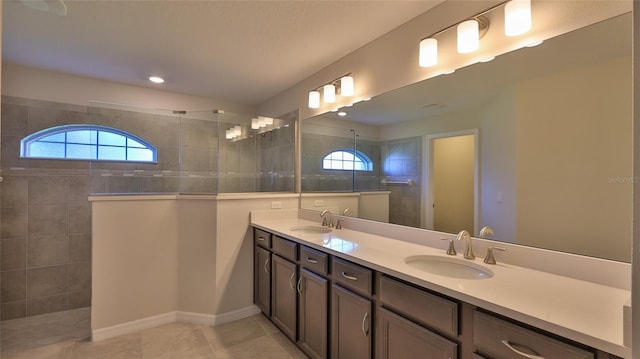 bathroom featuring vanity, tile patterned flooring, and a tile shower