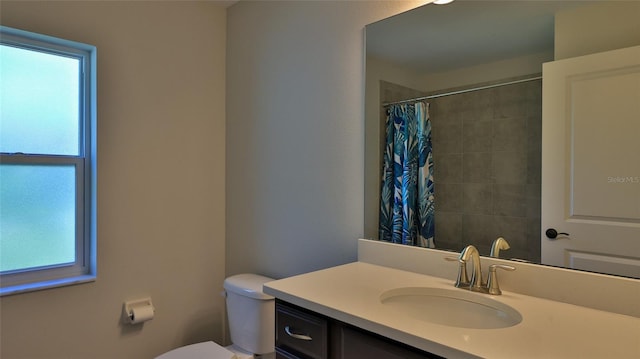 bathroom featuring vanity, toilet, a shower with shower curtain, and a wealth of natural light