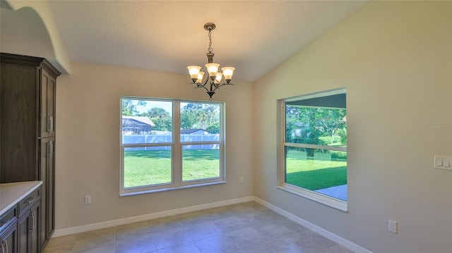 unfurnished dining area with an inviting chandelier, light tile patterned floors, and vaulted ceiling