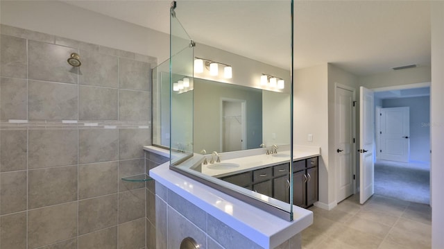 bathroom featuring vanity, tile patterned flooring, and tiled shower