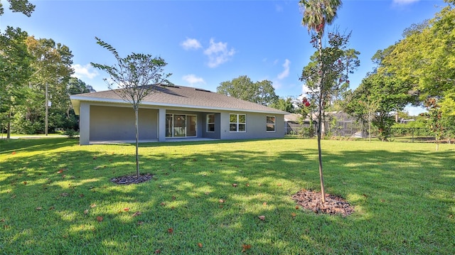 back of house featuring a lawn