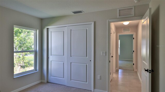 unfurnished bedroom with light tile patterned floors and a closet