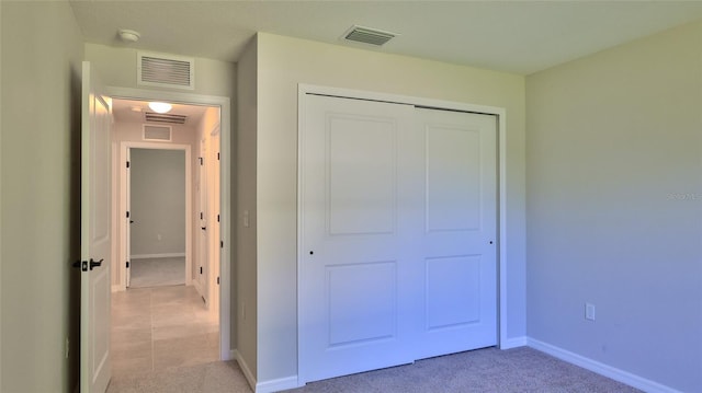 unfurnished bedroom with light carpet and a closet