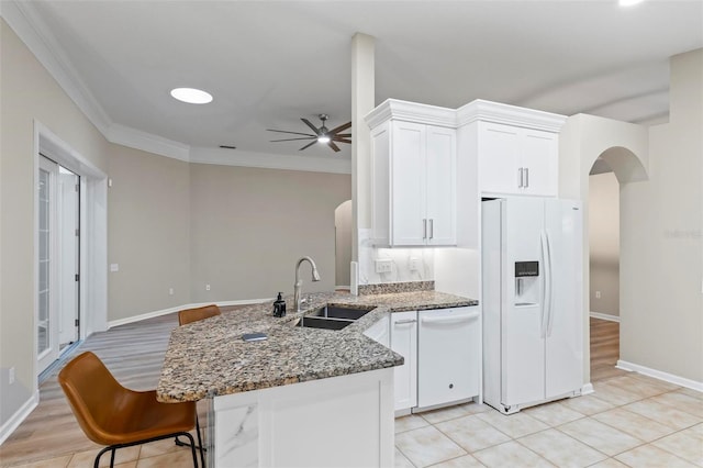 kitchen featuring sink, ceiling fan, stone counters, white appliances, and white cabinets