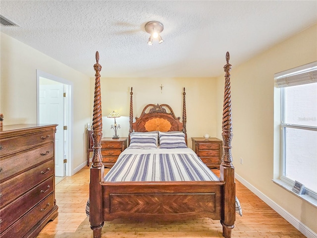 bedroom with light hardwood / wood-style flooring and a textured ceiling