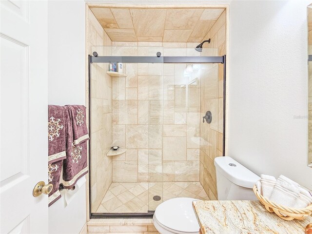 bathroom featuring walk in shower, vanity, and toilet