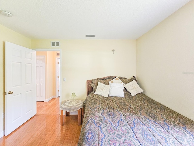 bedroom featuring wood-type flooring and a textured ceiling