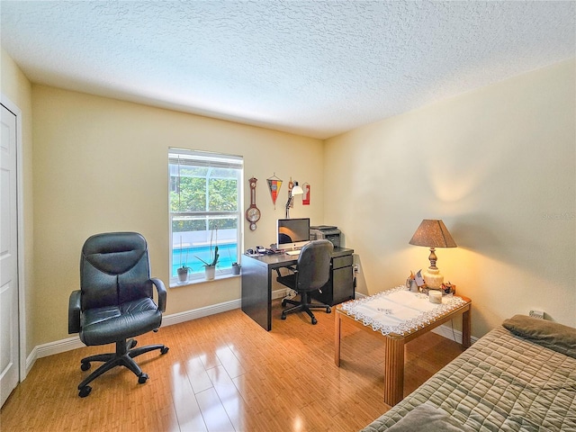 home office featuring a textured ceiling and light hardwood / wood-style floors