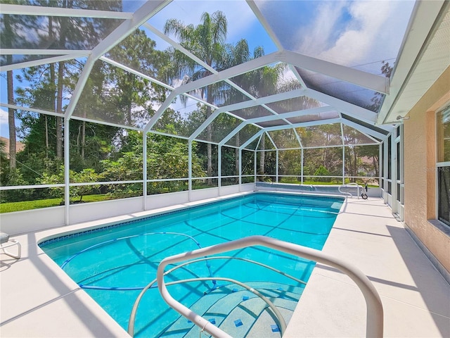 view of pool with a patio area and glass enclosure