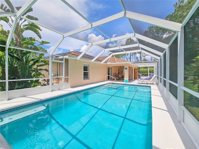 view of swimming pool featuring a patio and glass enclosure