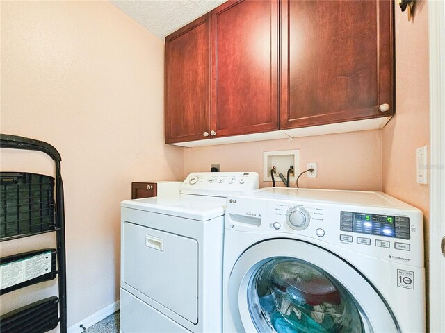 washroom featuring separate washer and dryer and cabinets