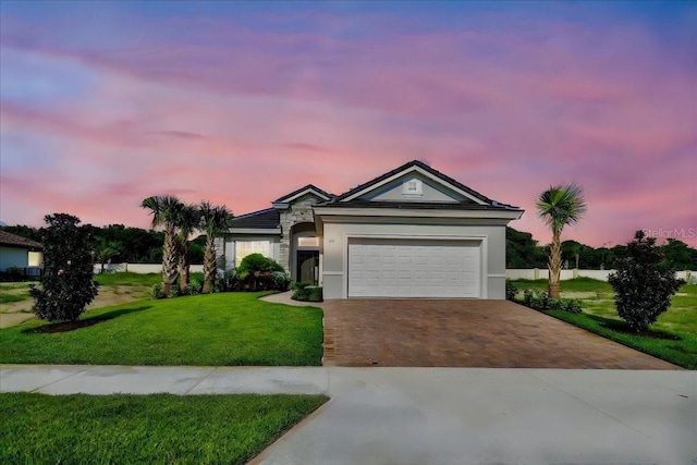 single story home with a garage and a lawn