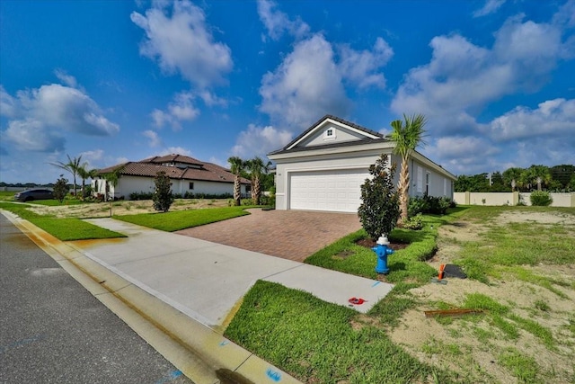 ranch-style home featuring a garage and a front lawn