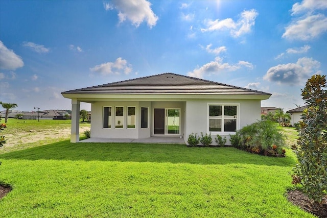 back of property featuring a patio and a yard