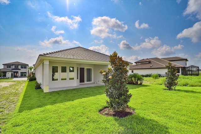 rear view of property featuring a yard