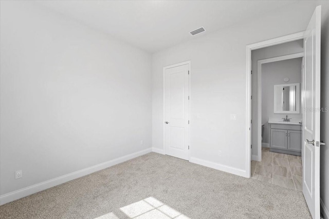 unfurnished bedroom with sink and light carpet