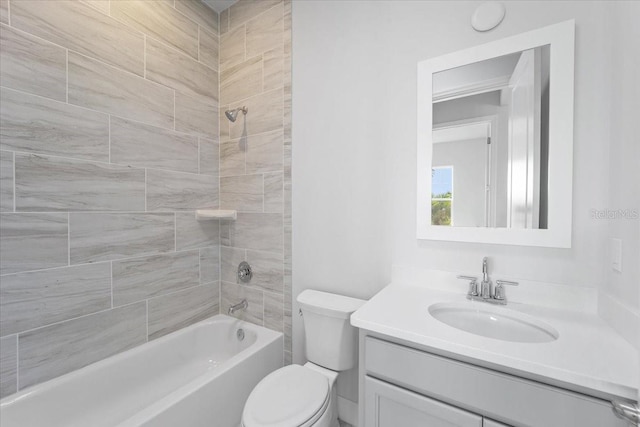 full bathroom with vanity, tiled shower / bath, and toilet